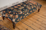 Antique Persian rug ottoman with classic cypress tree motif, terracotta blossoms, and a rich, time-softened patina.