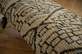 Plush, woven texture of the Moroccan rug ottoman featuring a dark gray and ivory geometric design.