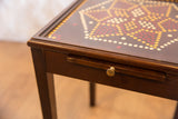 Detail of the vintage end table's drawer, showing aged brass knob and visible wood wear.