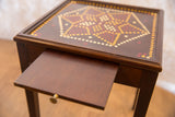 Vintage end table's dark brown partially open pull-out shelf with brass knob.