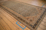 A long, angled view of a distressed Malayer runner's intricate Herati pattern and layered borders.