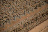 Storied low-pile texture of a vintage Persian Malayer runner with copper and navy floral details.