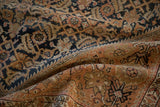 Detailed texture of a distressed Malayer rug showing even wear across the knot heads in copper and navy.