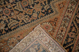 Corner of the vintage Malayer rug is folded back, showing the hand-knotted foundation.