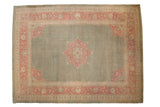 Distressed vintage Armenian Agra rug with muted green field, faded pink starburst medallion, floral border.