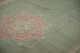 Faded pink floral medallion motif on distressed sea foam green Armenian Agra rug.