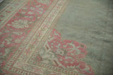 Distressed Armenian Agra rug border with faded magenta vinery and sage green field.