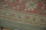 Distressed Armenian Agra carpet with sprawling vinery in faded magenta and pale coffee tones.