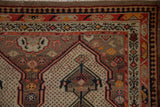 Vintage Malayer rug corner showing shield medallion, camel, red, ivory, navy patterns, even wear.