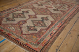 Vintage Malayer rug corner, featuring shield medallions, pale red and navy border patterns.