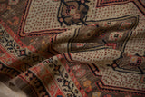Folded vintage Malayer rug showing camel seeded field, dark coral geometric motifs, even pile wear.