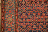Classic Turtle Samovar border in sky blue contrasting with the rug's dense navy Herati field.