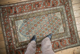 Distressed vintage Kurd rug texture, with slate blue-green lattice and rust geometric border.