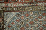 Kurd rug's geometric lattice meets meandering vine border in dusty blue-green, rust tones.