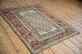 Distressed vintage Kurd rug: wide rust border with geometric vine, worn pile showing foundation.