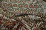 Distressed vintage Kurd rug with geometric panels and main border in rust and slate blue.