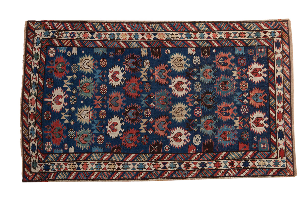 A late 19th-century Caucasian rug with oversized, serrated floral motifs on a deep sapphire blue field.
