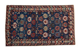 A late 19th-century Caucasian rug with oversized, serrated floral motifs on a deep sapphire blue field.