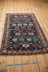 A high-angle view of the antique Caucasian rug showcasing its unidirectional geometric design.