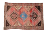 Vintage Malayer rug with triple diamond medallions in blue and brown on a striated blush-red field.