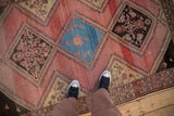 Contrasting diamond medallions and worn, striated texture of a vintage Persian Malayer rug.