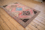 High-angle view of the vintage Malayer rug, showing its full medallion pattern and striated blush field.