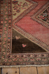 Expressively drawn birds in the corner spandrel of a distressed hand knotted Persian rug.
