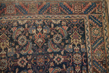 Detail of a fine Malayer rug's serrated leaf border next to its navy Herati-patterned field.