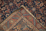 Folded corner of an antique Malayer rug showing its fine hand-knotted weave and secured fringe.