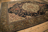 Antique Malayer carpet: ivory floral medallion, navy field of vines, and olive main border.