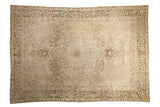 Antique Persian Kerman carpet, distressed ivory field with faded starburst medallion and floral vines.