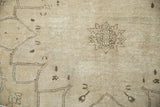 Persian Kerman rug detail: distressed antique ivory field, dark chocolate starburst, even wear.