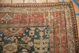 Worn corner of an antique Persian Bijar rug showing geometric borders in madder red and ivory.