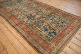 Angled view of an antique Bijar runner's intricate Harshang design and time-softened color palette.