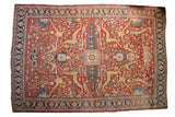 Antique Heriz carpet with a squared central medallion, oversized arabesques, and a rich cherry red field.