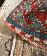 Antique Kazak rug's woven side cord and vibrant gem-tone geometric border.