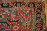 Close-up of the vintage Heriz carpet corner, showing the serrated leaf and pomegranate design border.