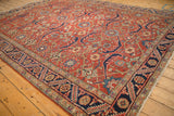 Low angle view across the vintage Heriz carpet, detailing the low pile and bold navy border.