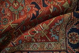 Close-up of a vintage Heriz carpet's cherry red pile, with crab motifs and serrated leaves.