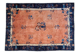 Antique Peking carpet, pale copper field, central floral vase, and navy blue floral border.