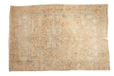 A distressed vintage Heriz carpet with a geometric diamond medallion and borders in soft cream and dusty blue.