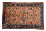 Antique Persian Lilihan carpet with a floral medallion, distressed copper field, and contrasting dark navy border.