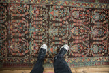 Detailed view of paisley botehs with interior tree of life motifs on a chocolate brown Persian runner.