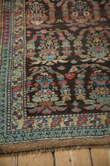 Angled view of the vintage Persian runner's corner showing the complex border and low-pile texture.