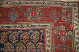 Corner detail of the antique rug's boteh field and geometric-floral border.