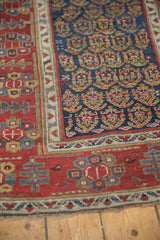Intricate red border and navy blue boteh field on a late 19th-century Persian rug runner.