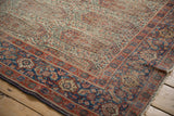 Antique Senneh rug detail: intricate Herati border and floral field in terra cotta, indigo, ivory, with wear.