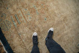Antique Art Deco carpet showing low pile texture and visible knot heads in beige and blue.