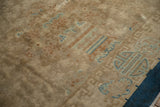 Low pile texture of an antique Art Deco carpet with tone-on-tone beige motifs and blue geometric details.