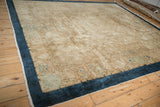 Detailed corner view of a Chinese Art Deco carpet's solid blue border and textured beige field.